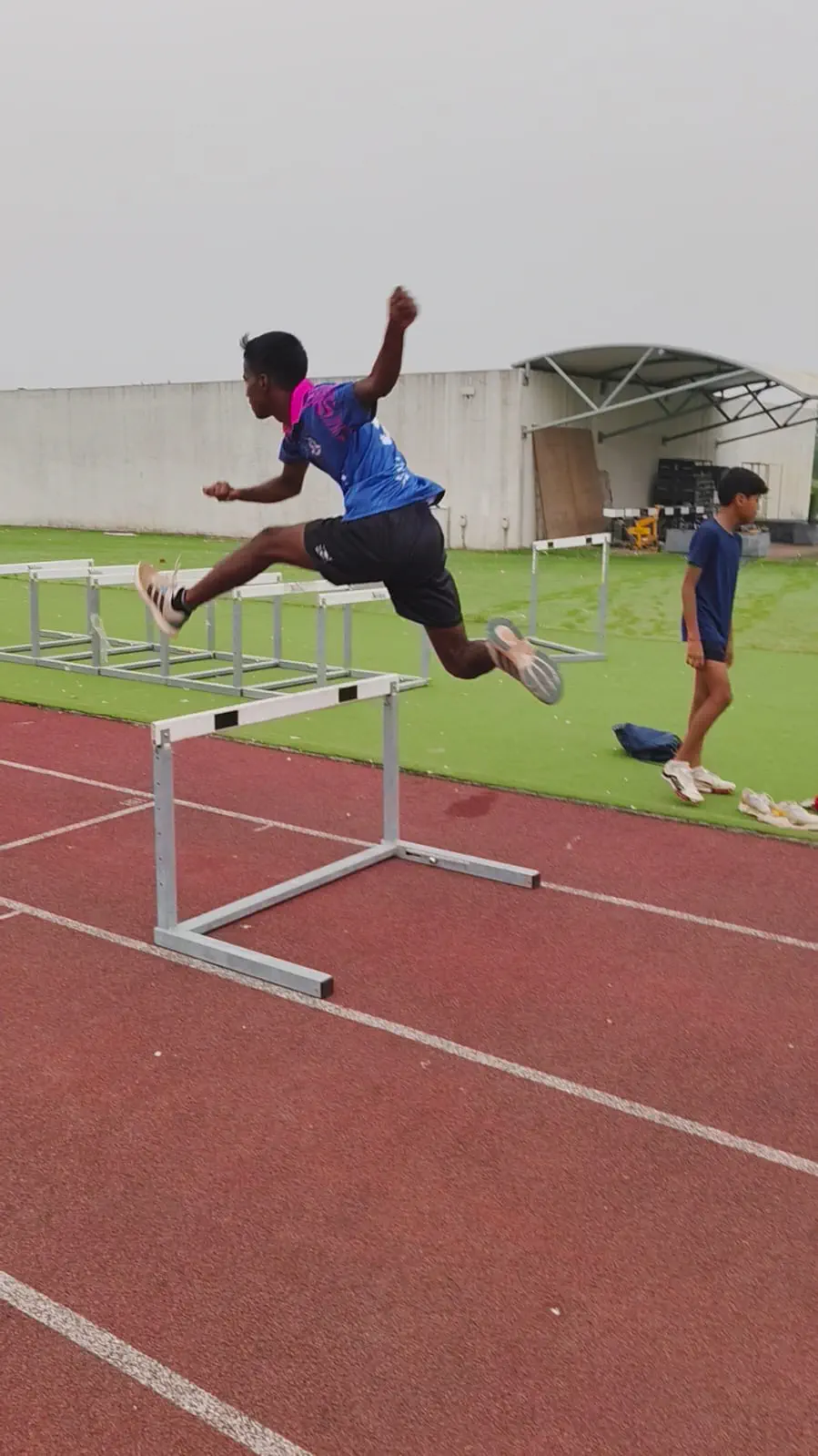 Young child running hurdles speed drill at complex